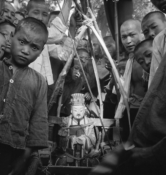 Men carrying a local rain god in a procession through a village on the way to the Lost Tribe country