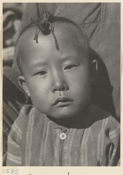 Child with topknot wearing striped shirt