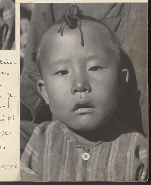 Child with topknot wearing striped shirt