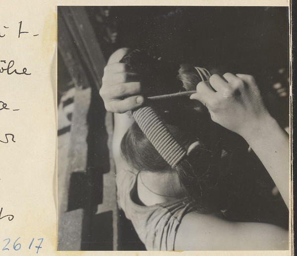 Woman doing her hair in the traditional teapot style in the Lost Tribe country