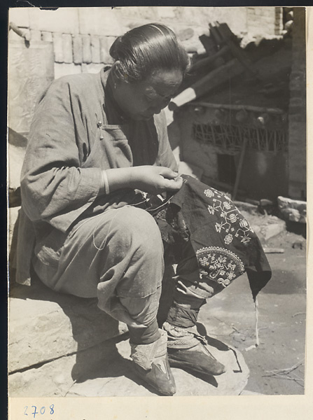 Woman embroidering a cotton apron in Lo-pu-ch'iao Village [sic] in the Jumahe Valley