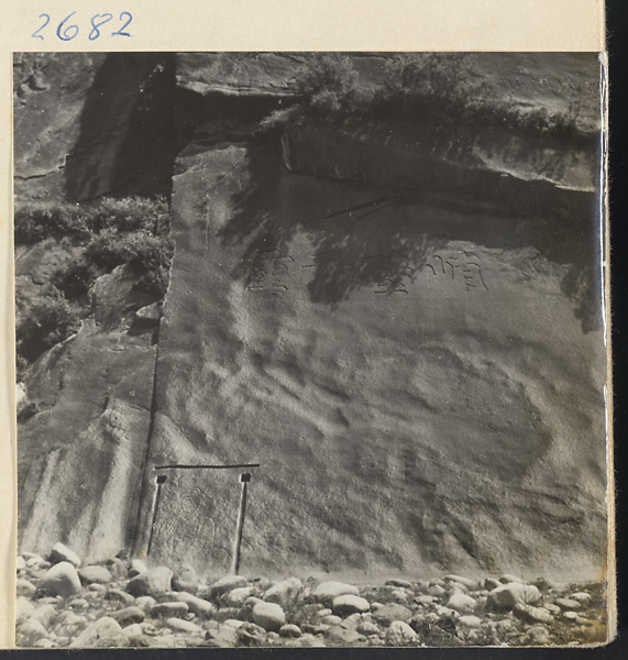 Inscriptions and figure of Buddha carved in rock wall along river in the Lost Tribe country