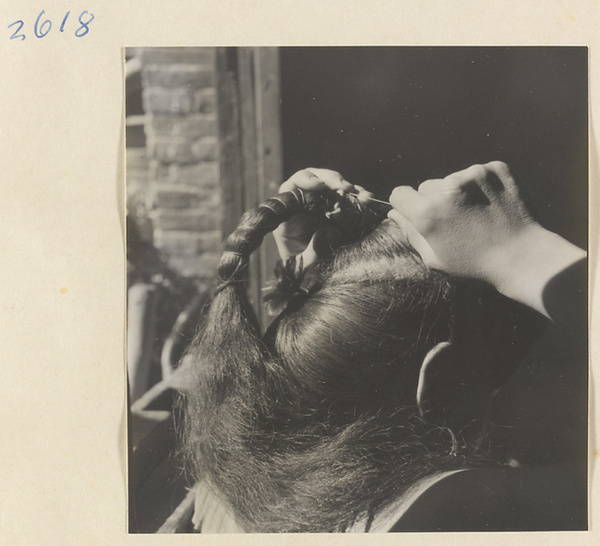 Woman doing her hair in the traditional teapot style in the Lost Tribe country