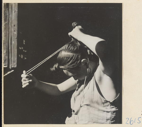 Woman doing her hair in the traditional teapot style in the Lost Tribe country