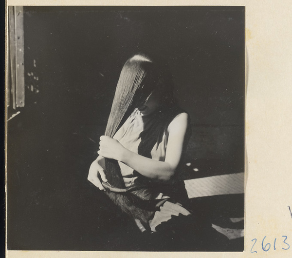 Woman doing her hair in the traditional teapot style in the Lost Tribe country