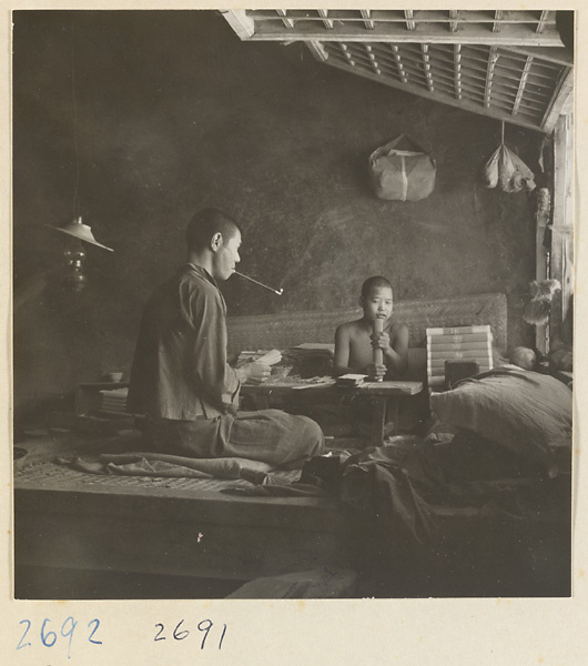 Man with pipe and boy bundling incense at factory west of Ts'a-ho Village [sic] in the Lost Tribe country