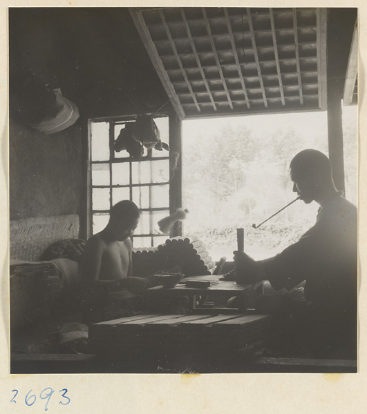 Man with pipe and boy bundling incense at factory west of Ts'a-ho Village [sic] in the Lost Tribe country