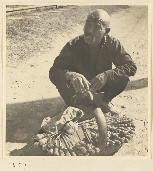 Street vendor hawking candied fruit called tang hu lu from a basket in Baoding