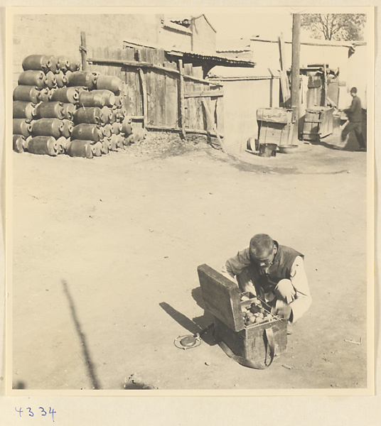 Street vendor with box of sewing thread and a gong called a yun luo or ling zi in Baoding