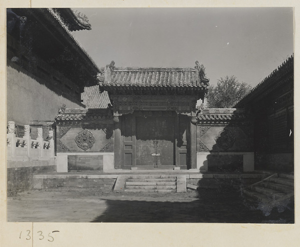 Gate with glazed-tile relief work on flanking walls in the Forbidden City