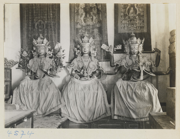 Interior of temple building at Yong he gong showing three Lamaist deities, one with multiple heads and arms, and hanging scroll paintings