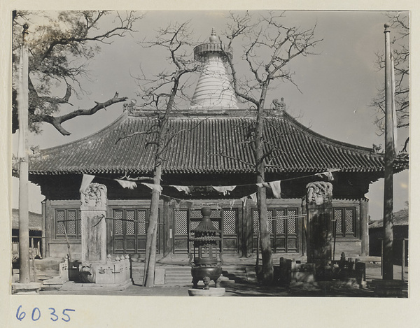 Facade of temple building at Bai ta si showing flags, tortoise stelae, and incense burner