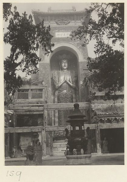 Facade detail of Da Fo si showing a giant statue of a Bodhisattva, signboard, and incense burner