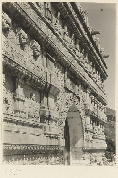 Detail of Jin gang ta at Bi yun si showing entrance and relief carvings of Buddha figures and animal heads