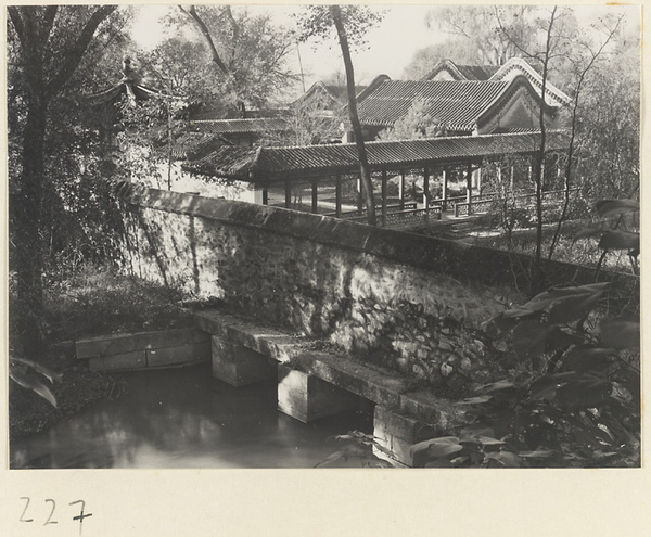 Trees, wall, covered walkway, and single-eaved buildings at the Old Wu Garden