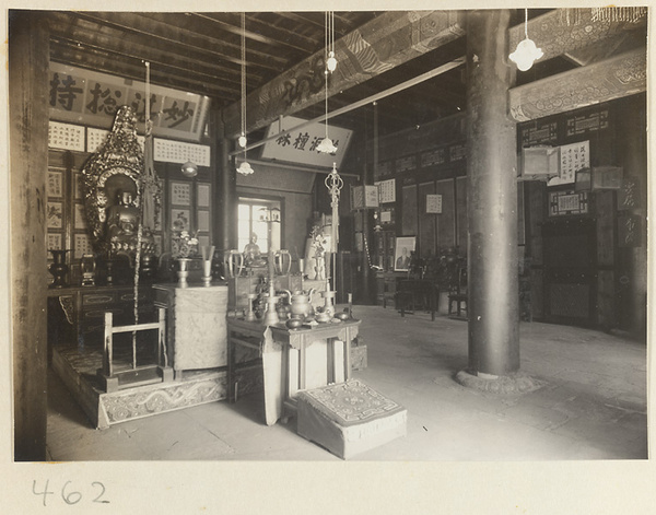 Temple interior showing altars with Buddha statues, ritual objects, scrolls, and a portrait at Fa yuan si