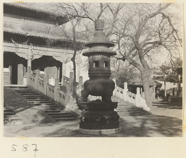 Facade detail of a double-eaved temple building showing terrace, stairs with carved marble slab, and incense burner at Huang si