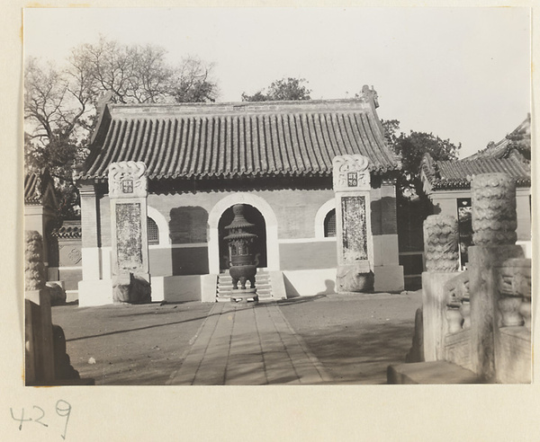 Temple building and courtyard with tortoise stelae and incense burner seen from bridge at Bai yun guan