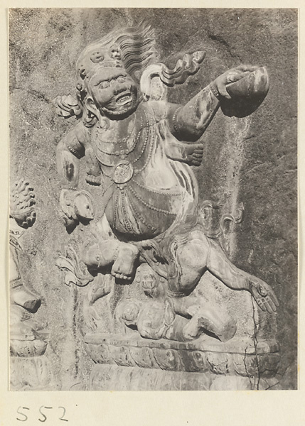 Buddhist relief figure with headdress of skulls carved into the hillside at Yuquan Hill