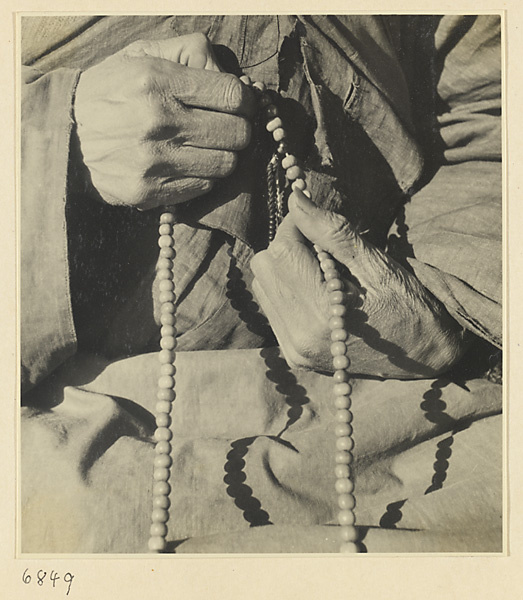 Buddhist nun holding a string of rosary beads