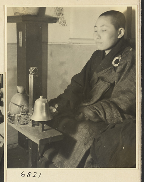 Buddhist nun striking a mu yu and a metal bell