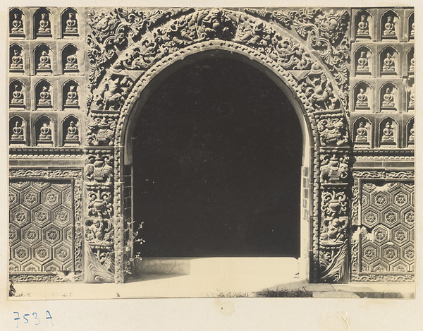 Detail of Liu li ge showing arched doorway with glazed ceramic tiles and walls with Buddha reliefs