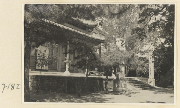 Facade detail of a temple building at Jie tai si showing stairs flanked by two stone stelae and terrace with a sundial