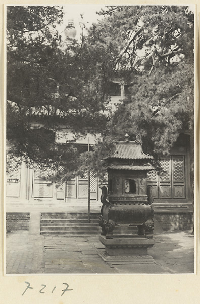 Incense burner in front of a two-story, double-eaved temple building at Jie tai si