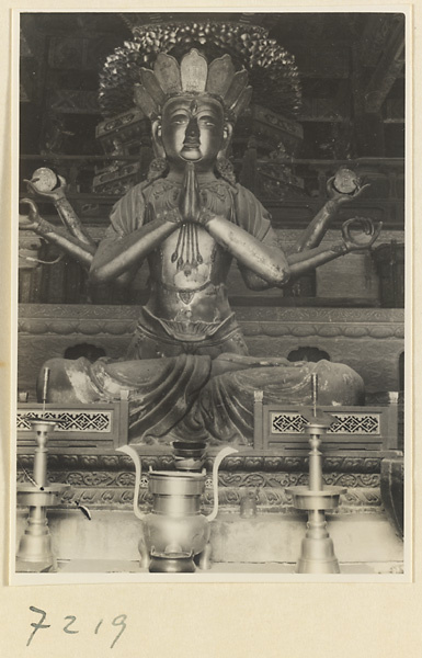 Temple interior at Jie tai si showing altar with a six-armed Bodhisattva