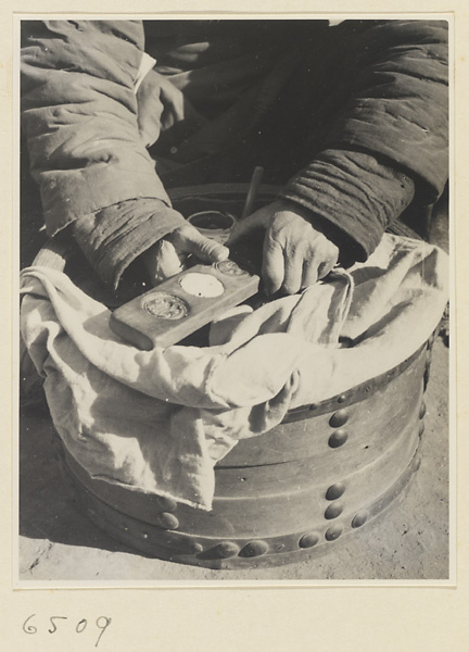 Candy vendor with box of equipment making candy with a mold