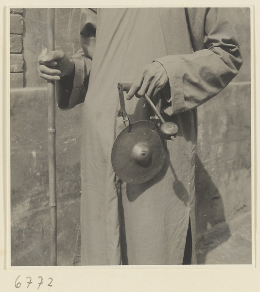 Blind fortune teller with staff and hand gong called tong dian or dian zi