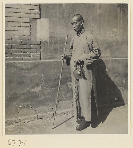 Blind fortune teller with staff and hand gong called tong dian or dian zi