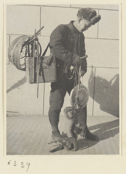 Entertainer with performing monkey and gong called a luo