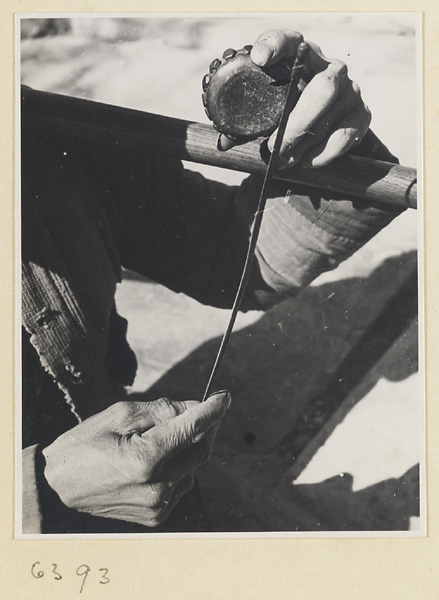 Itinerant vendor striking a drum called a xiao gu