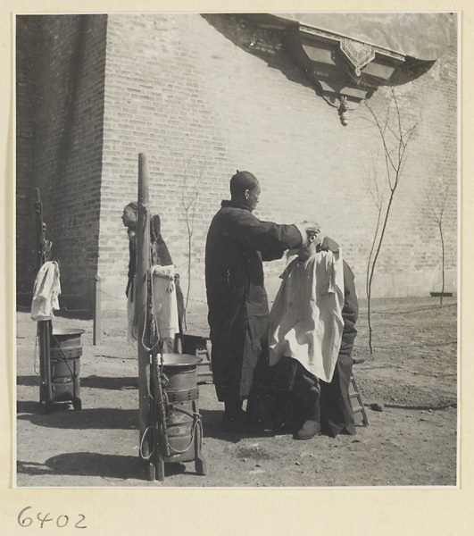 Street barber shaving a man's head