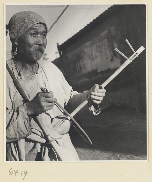 Garlic vendor playing a stringed instrument