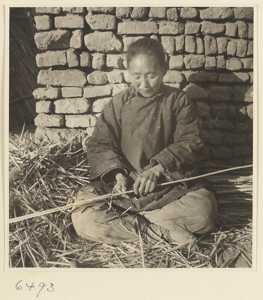 Woman splitting reeds at a mat-making shop