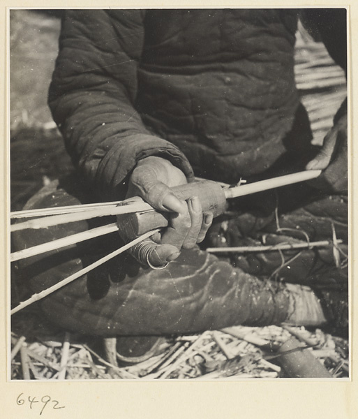 Man splitting reeds at a mat-making shop