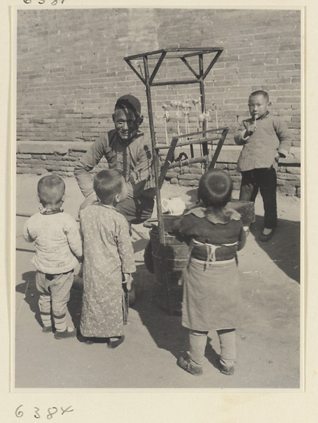 Boys buying blown candy from street vendor