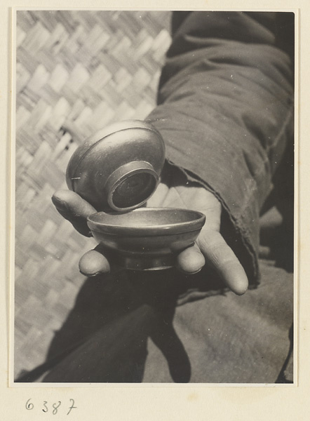 Drink vendor displaying metal hand clappers called bing zhan