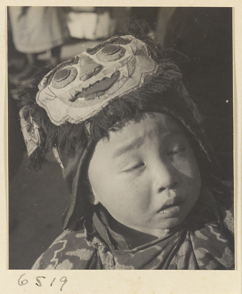 Child wearing a hat with animal-face motif