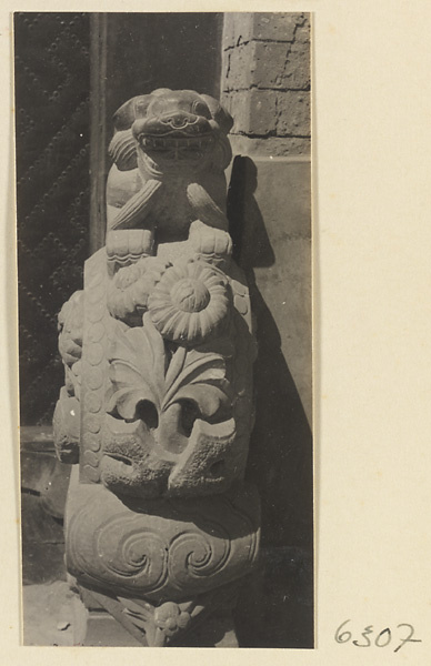 Carved door stone with floral and ling zhi fungus motifs and animal finial