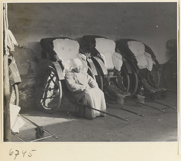 Man sitting on a rickshaw at a rickshaw stand