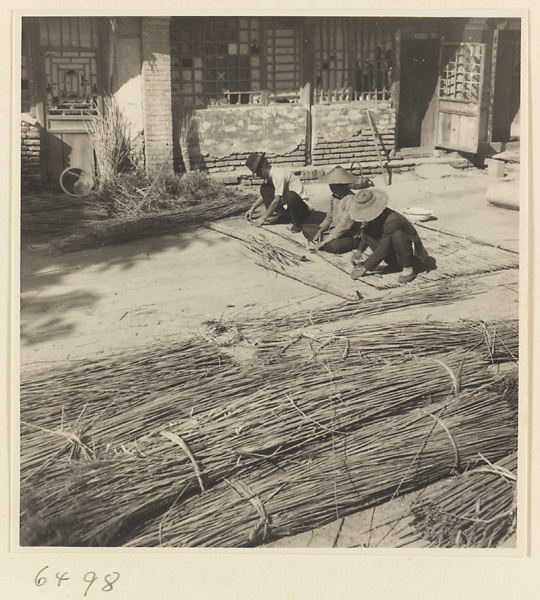 People weaving a mat at a mat-making shop