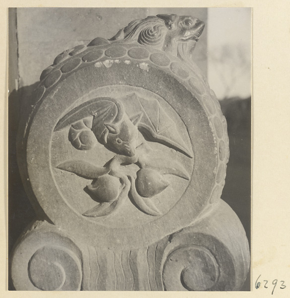 Carved door stone with bat and peach motifs