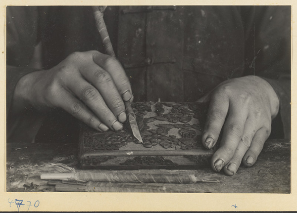 Boy carving lacquer in a workshop