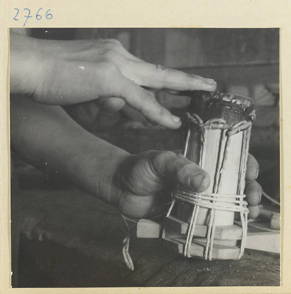 Man working on the wooden body of a stringed instrument in a workshop