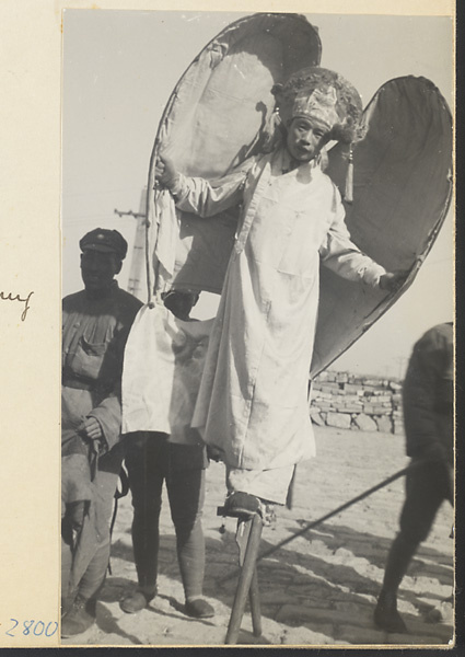 Soldier in winged costume at New Year's walking on stilts