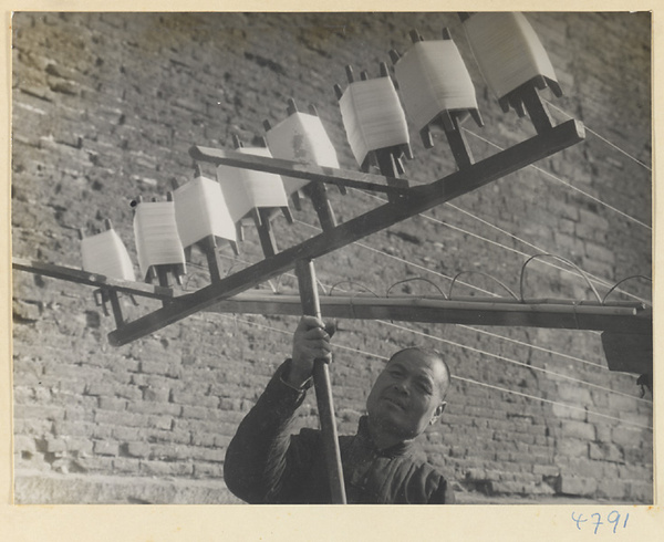 Silk spinner holding reels of silk thread