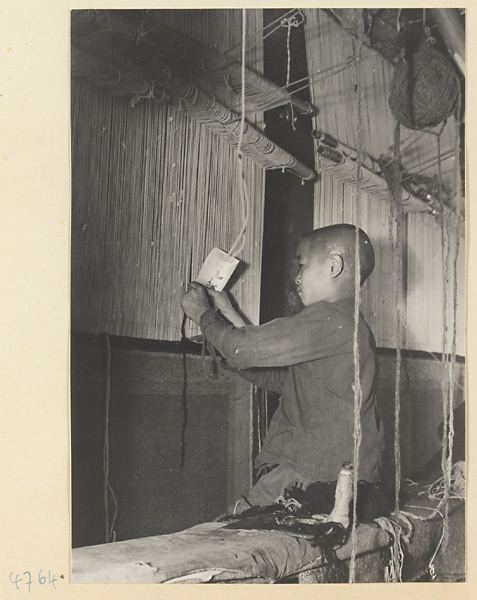 Boy working at a carpet loom